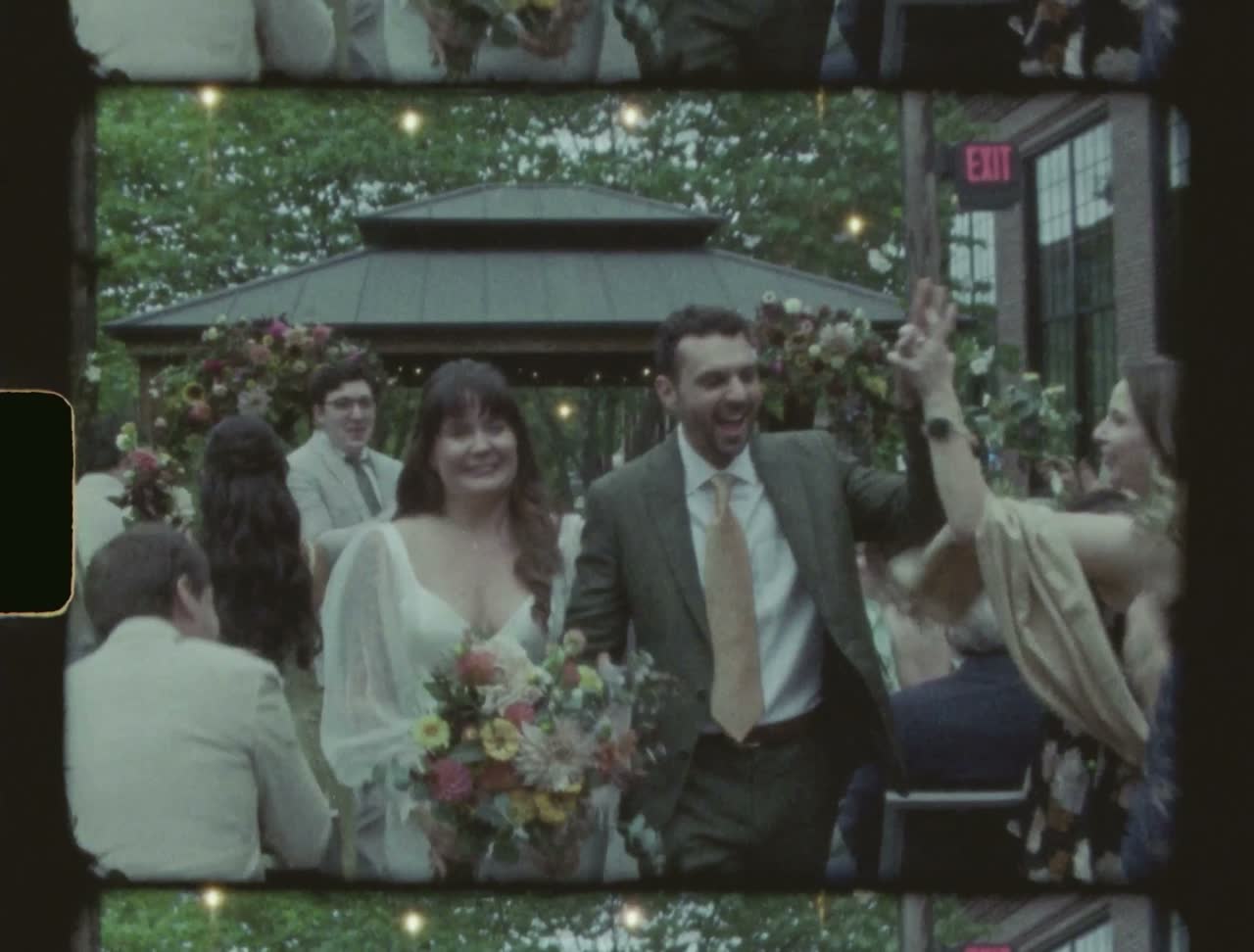 Couple walking back up the aisle, guests cheering